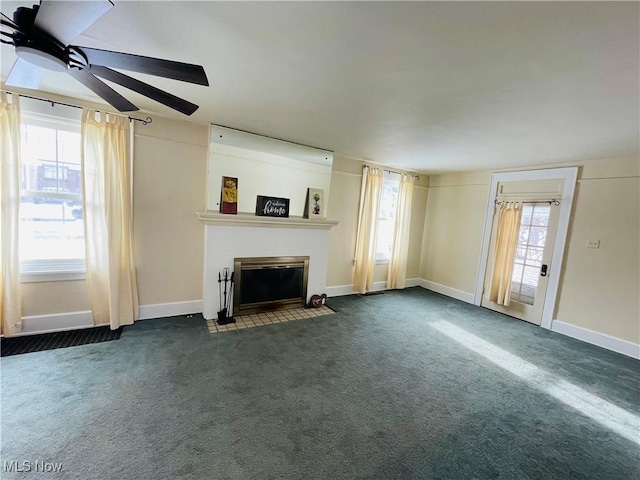 unfurnished living room featuring dark carpet and ceiling fan