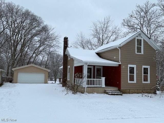 view of front of home with covered porch, a garage, and an outdoor structure