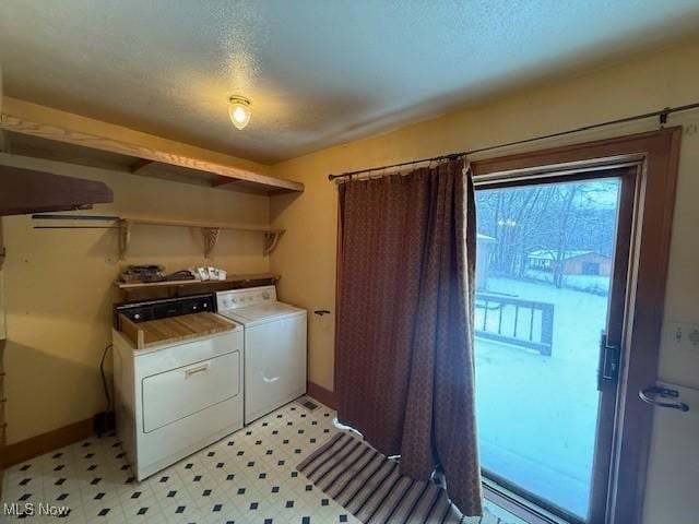 washroom with washing machine and dryer and a textured ceiling