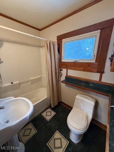 full bathroom with sink, shower / bath combo, toilet, and crown molding