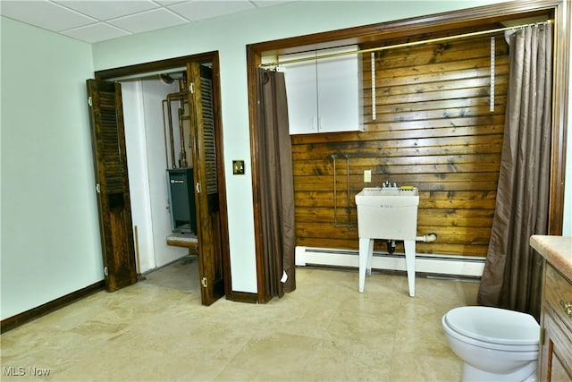 bathroom with a paneled ceiling and baseboard heating