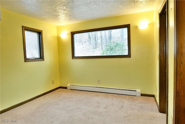 carpeted empty room with a textured ceiling and baseboard heating