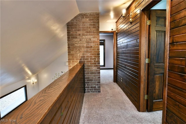 corridor featuring plenty of natural light, light colored carpet, and lofted ceiling