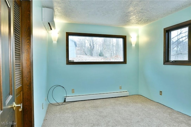 empty room with a wall unit AC, carpet flooring, a baseboard radiator, and a textured ceiling