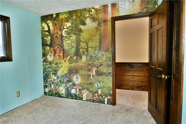 carpeted empty room with a textured ceiling