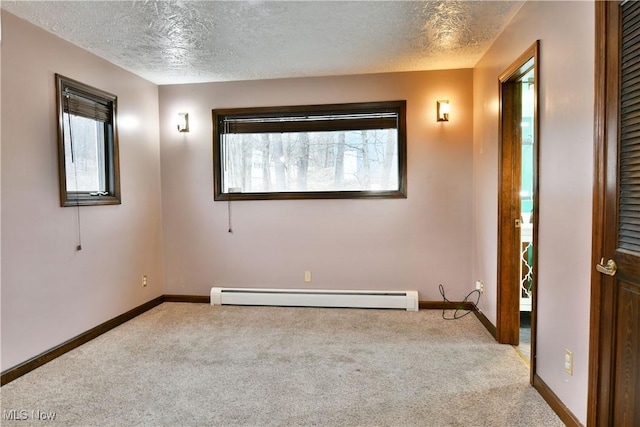 carpeted spare room featuring a textured ceiling and baseboard heating