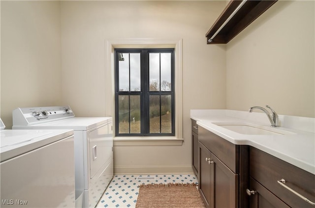 washroom with cabinets, sink, and washing machine and clothes dryer