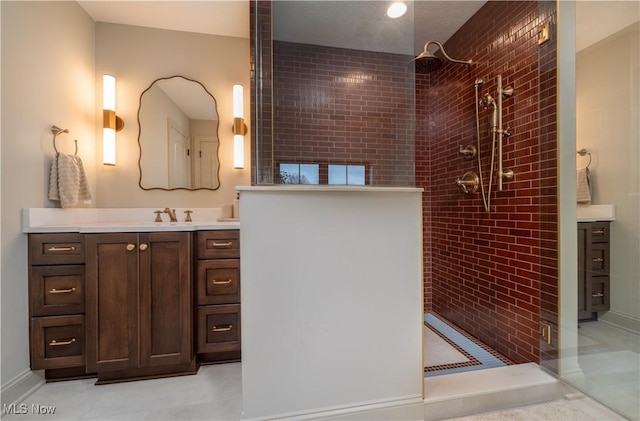 bathroom with vanity and a tile shower