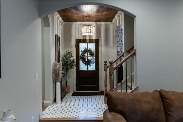 carpeted foyer entrance with an inviting chandelier