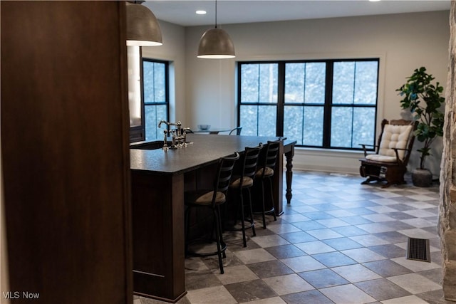 kitchen with pendant lighting, sink, and a kitchen breakfast bar