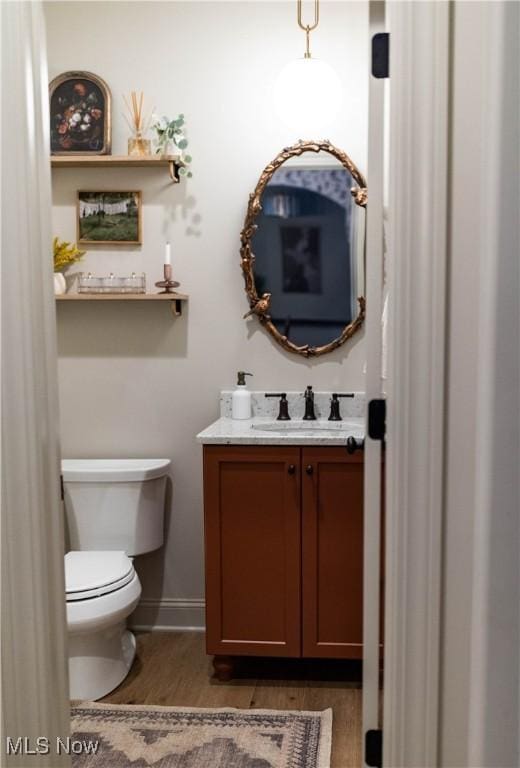 bathroom featuring vanity, hardwood / wood-style floors, and toilet