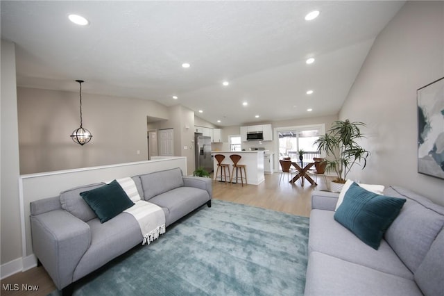 living room with light hardwood / wood-style flooring and lofted ceiling