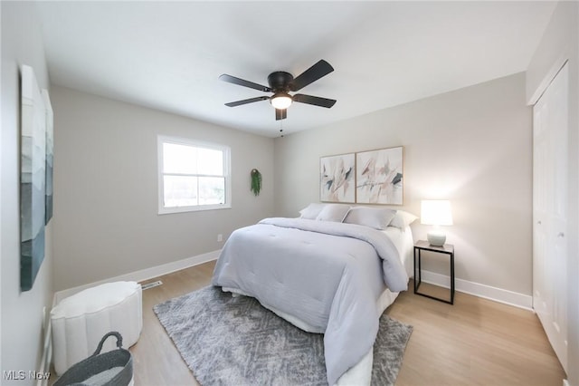 bedroom featuring ceiling fan, a closet, and light hardwood / wood-style floors