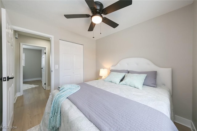 bedroom featuring ceiling fan, light hardwood / wood-style floors, and a closet