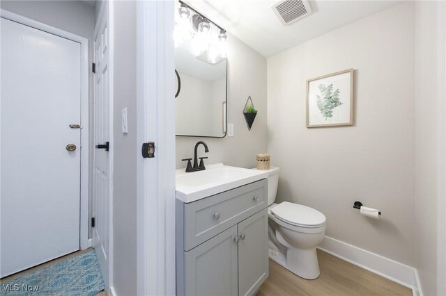 bathroom featuring hardwood / wood-style floors, vanity, and toilet