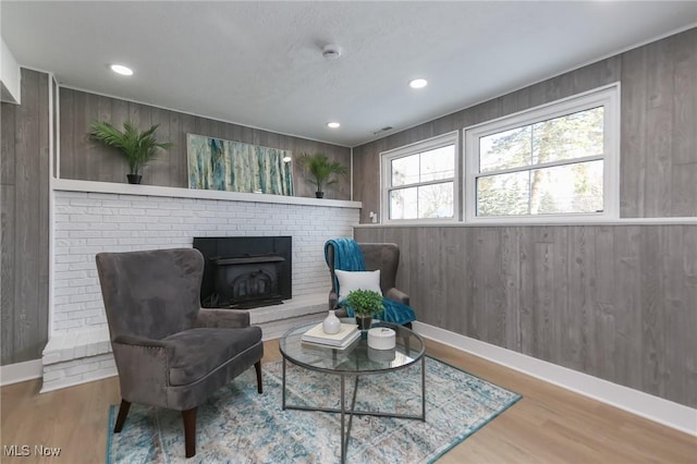 living area featuring hardwood / wood-style flooring and wooden walls