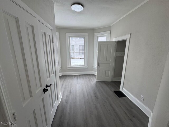 hallway featuring dark hardwood / wood-style flooring and ornamental molding