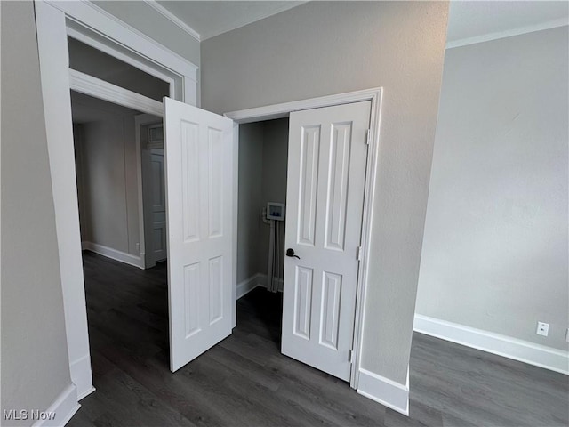 corridor featuring crown molding and dark hardwood / wood-style flooring