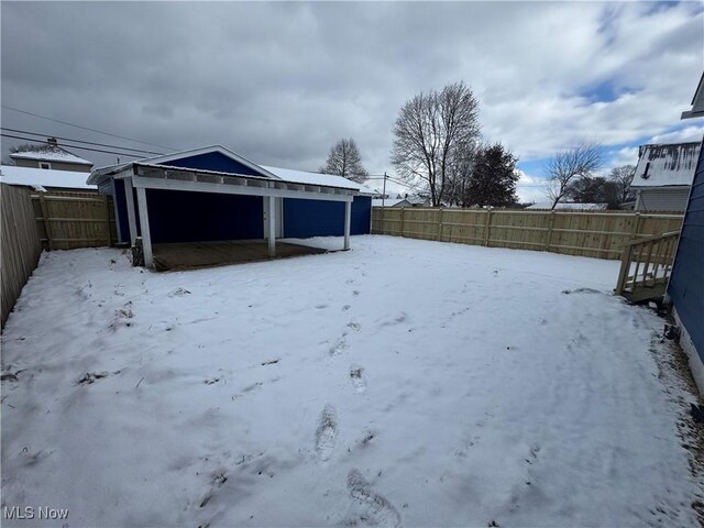 yard covered in snow with an outbuilding