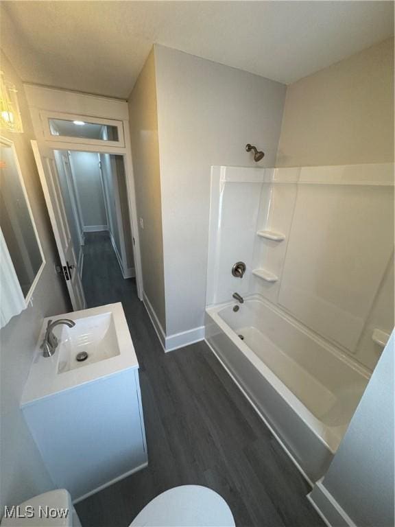 full bathroom featuring hardwood / wood-style floors, vanity, shower / bathtub combination, and toilet