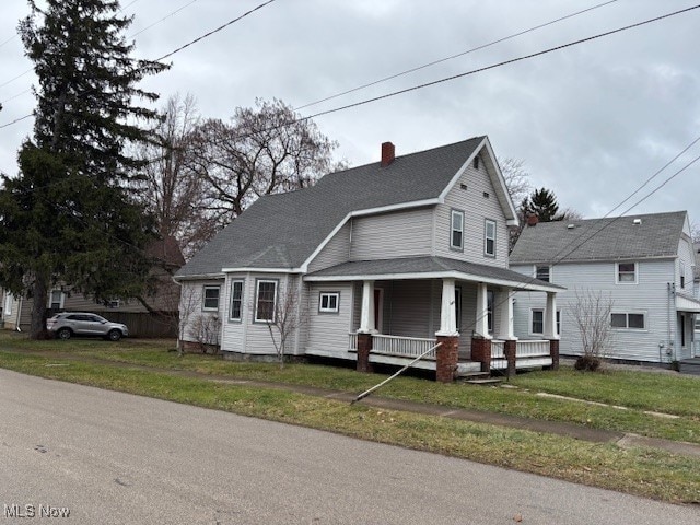 view of front facade featuring covered porch and a front lawn