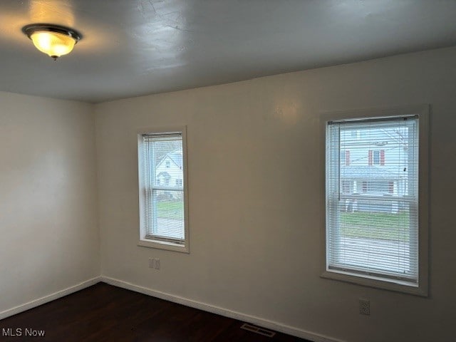 unfurnished room featuring dark hardwood / wood-style flooring