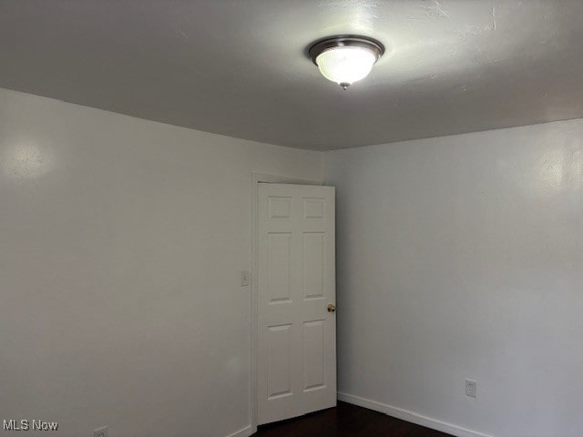 spare room with dark hardwood / wood-style flooring