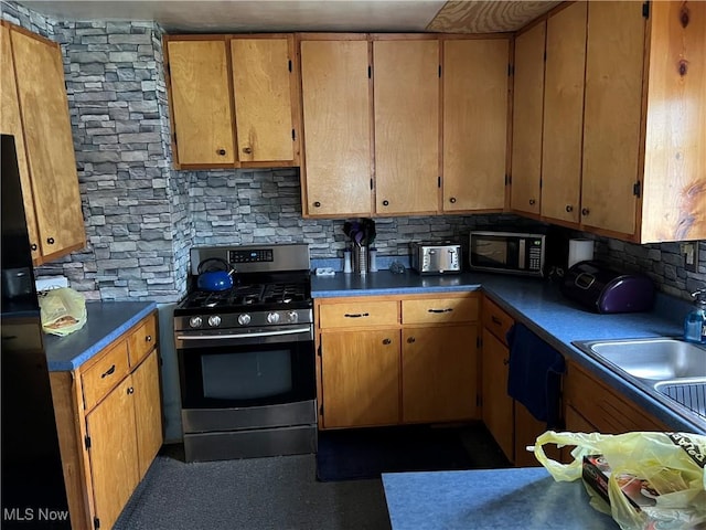 kitchen with decorative backsplash, sink, and black appliances