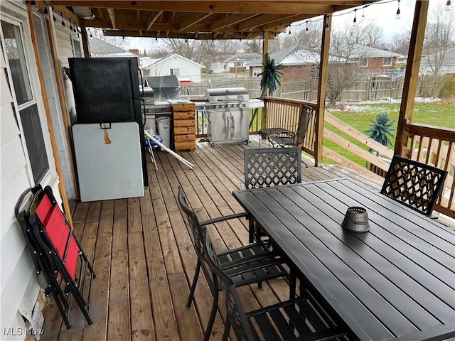 wooden deck featuring grilling area and a lawn