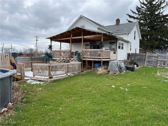 rear view of property with a lawn and a wooden deck