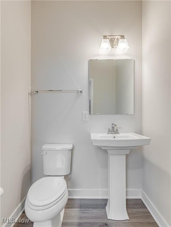 bathroom featuring hardwood / wood-style flooring, toilet, and sink