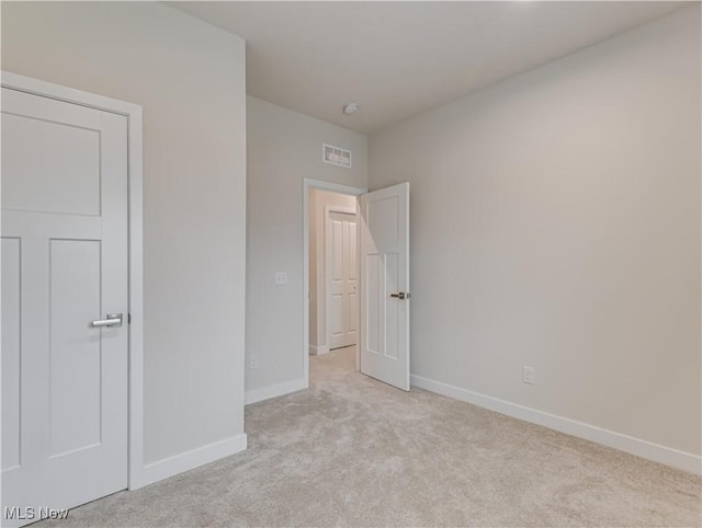 unfurnished bedroom featuring light colored carpet and a closet