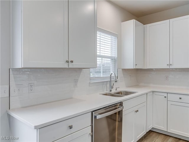 kitchen with dishwasher, decorative backsplash, white cabinetry, and sink