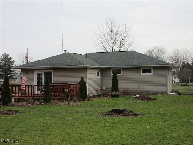 back of property with a lawn and a wooden deck