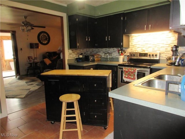 kitchen with decorative backsplash, stainless steel electric range oven, ceiling fan, and light tile patterned floors