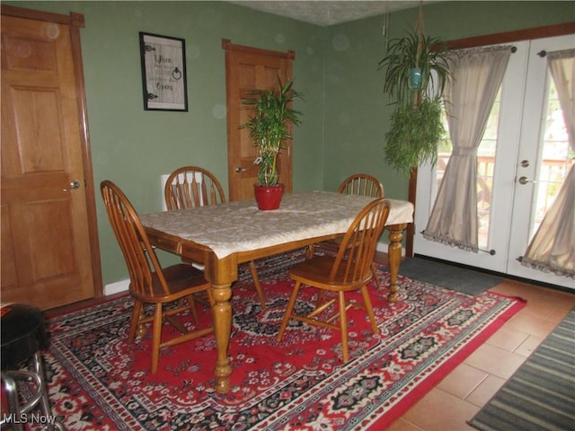 tiled dining room featuring french doors