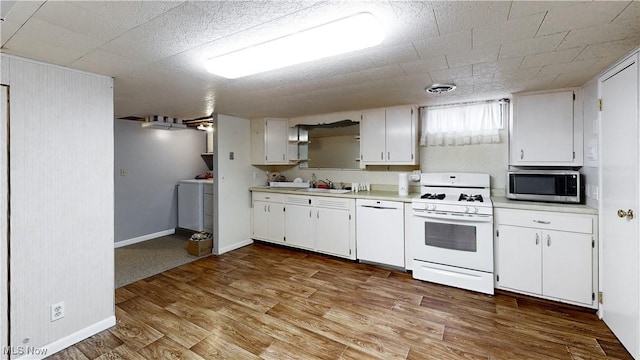 kitchen featuring white cabinets, light hardwood / wood-style floors, white appliances, and sink