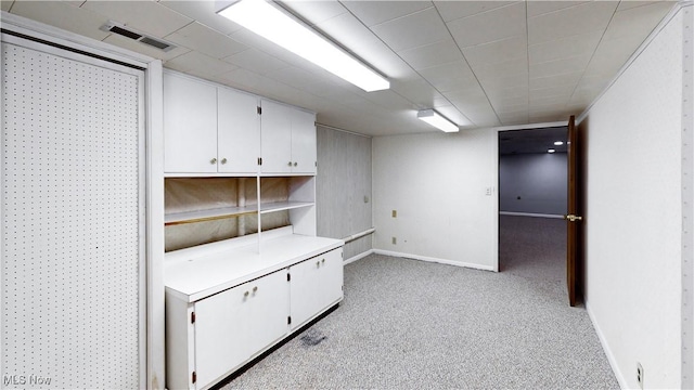 interior space with white cabinetry and light carpet