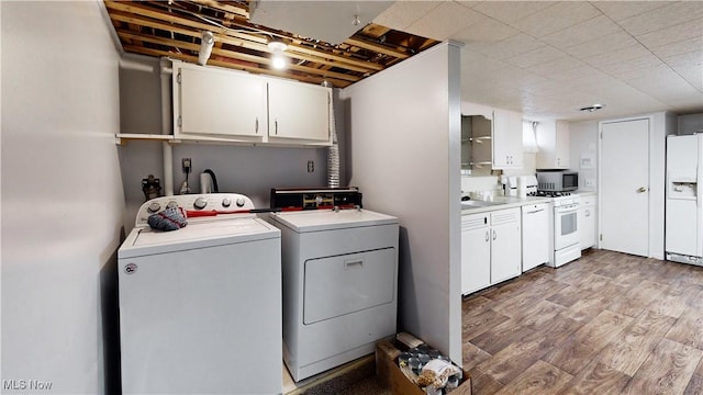 laundry area with washer and clothes dryer, sink, and light hardwood / wood-style flooring