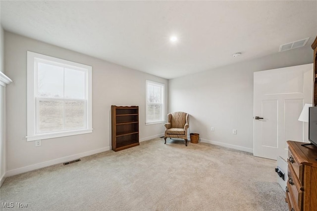 living area featuring light carpet