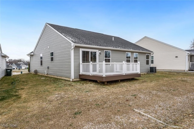 back of house featuring a yard, a wooden deck, and central air condition unit