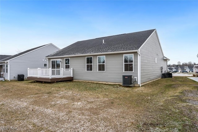 rear view of property with a lawn, a deck, and central AC