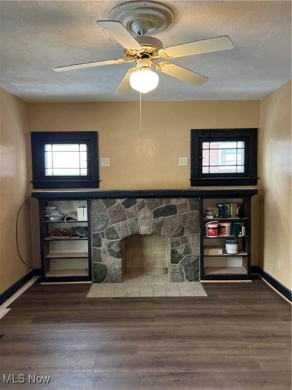 unfurnished living room featuring dark hardwood / wood-style floors, ceiling fan, and a healthy amount of sunlight