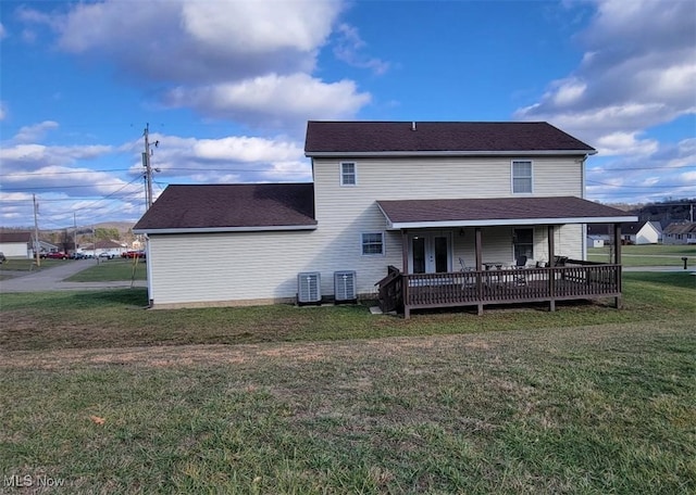 back of house with central AC, a deck, and a lawn