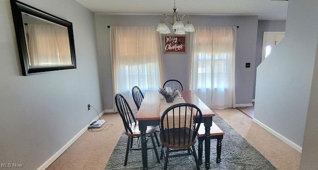 carpeted dining room featuring an inviting chandelier