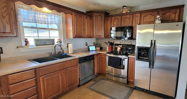 kitchen with sink, light tile patterned floors, and appliances with stainless steel finishes