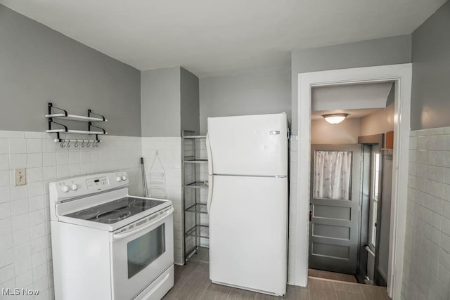 kitchen featuring white appliances and tile walls