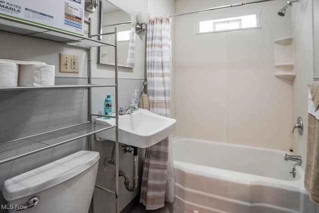 bathroom featuring shower / tub combo and toilet