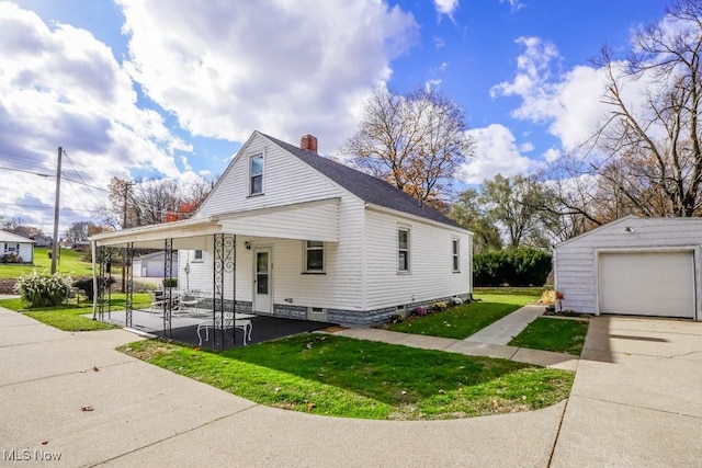 view of front of property with covered porch, a garage, a front lawn, and an outdoor structure