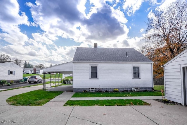 view of side of property with a yard and a carport